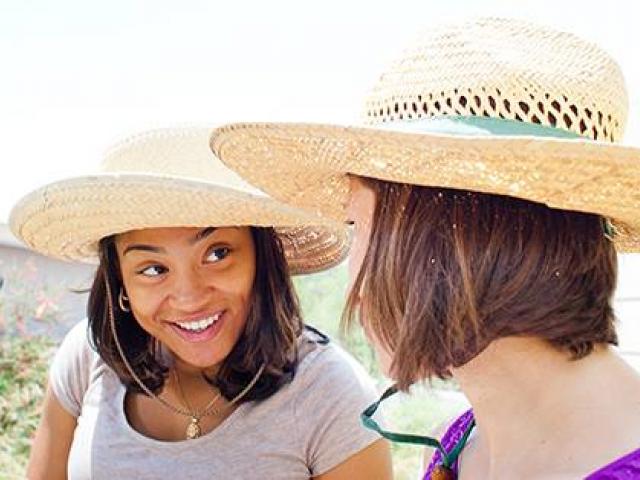 Two women wearing hats smiling